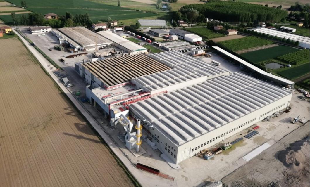 Vista aerea di un complesso industriale circondato da campi e vegetazione.